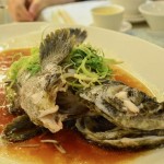 Steamed fish with leek and soya sauce, a traditional cooking style.